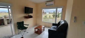 sala de estar con sofá, TV y silla en Buena Vista en San Andrés de las Sierras