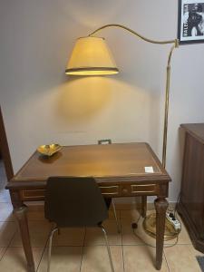 a desk with a lamp and a desk chair at Dolce Milano in Milan