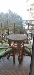 een rieten tafel en stoelen op een balkon bij Victoria bilocale centro città e vista mare in Menton