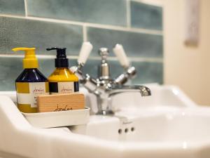 umywalkę w łazience z 2 butelkami dezodorantów w obiekcie 4 Bed in Melbury Abbas 48814 w mieście Melbury Abbas