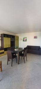 een woonkamer met een tafel, stoelen en een bank bij Victoria bilocale centro città e vista mare in Menton