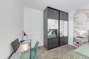 a room with a bed and a desk with a laptop at 44m² - Cosy - Neuf - Parking in Massy