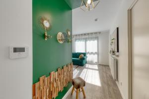 uma sala de estar com uma parede verde e uma cadeira em 44m² - Cosy - Neuf - Parking em Massy