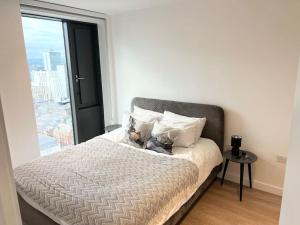 łóżko w pokoju z dużym oknem w obiekcie 2bedroom luxury apartment city centre V w Manchesterze