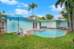 een huis met een zwembad en een parasol bij Zach's Tropical Pool House in Fort Lauderdale