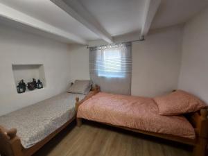 a bedroom with two beds and a window at Zsindely Ház Károlyfalva Sátoraljaújhely in Sátoraljaújhely