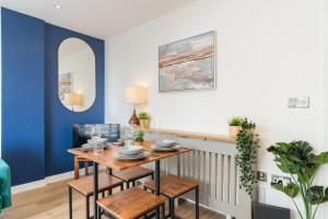 une salle à manger avec des murs bleus, une table et des chaises dans l'établissement Queen Anne House near Gunwharf Quays, Portsmouth with FREE PARKING, à Portsmouth