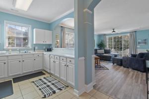 a kitchen with white cabinets and a living room at Arbor Trace #811 condo in North Myrtle Beach