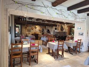 - un restaurant avec des tables et des chaises dans une salle dans l'établissement Auberge Le Sillet, à Longcochon