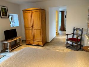 1 dormitorio con un gran armario de madera y TV en L'auberge'Inn, en Coulon