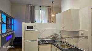 une cuisine avec des armoires blanches et un micro-ondes dans l'établissement Estudios Céntricos RH - Altamar, à Santander 42 autres photos