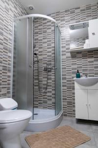 uma casa de banho com um chuveiro, um WC e um lavatório. em Farkas Villa Apartmanok em Mórahalom