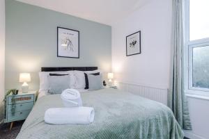 a white bedroom with a large bed with towels on it at Stylish House in Manchester Sleeps7 Wifi & Parking by PureStay in Manchester