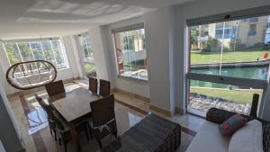 sala de estar con mesa y sillas y vistas a la piscina en Sotogrande - SotoLUX, en Sotogrande