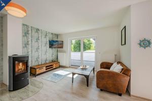 Villa Doris Whg 4 Sonnenblick في هيرينجسدورف: غرفة معيشة مع أريكة ومدفأة