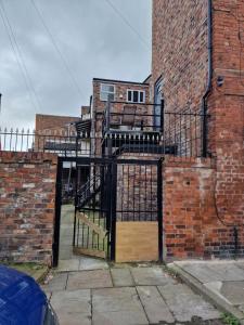 an entrance to a brick building with a black gate at Spacious Double Bedroom in Liverpool