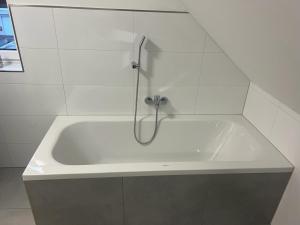 y baño con bañera blanca y ducha. en Murtal Appartment Größingblick en Zeltweg