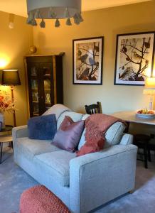 a couch with pillows on it in a living room at Holmlea Cottage in Moffat