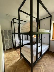 a room with three bunk beds in a room at 2nd Station Hostel in Bled