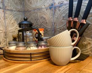 a tray with a coffee maker and a cup on a table at Holmlea Cottage in Moffat