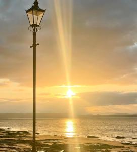 una luz de la calle en la playa con la puesta de sol en Invernairne, en Nairn