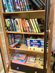 een boekenplank gevuld met veel boeken bij Holmlea Cottage in Moffat