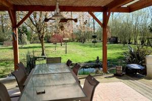 a patio with a table and chairs and a grill at la petite cabane in Maillé