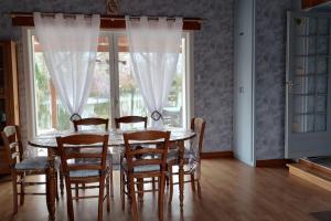 a dining room with a table and chairs and a window at la petite cabane in Maillé