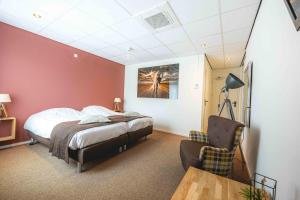 - une chambre avec un lit, une chaise et une table dans l'établissement De Klomp Charme Hotel & Restaurant, à Vilsteren