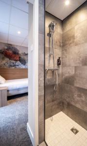 a bathroom with a shower with a bed in the background at Fletcher Hotel Restaurant Doorwerth - Arnhem in Doorwerth