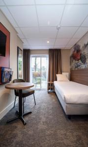 a hotel room with a bed and a desk and a table at Fletcher Hotel Restaurant Doorwerth - Arnhem in Doorwerth