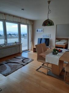 een woonkamer met een tafel en uitzicht op het water bij Obst- Und Ferienhof Marschall in Wasserburg