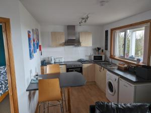 a small kitchen with a table and chairs in it at Burray Apartments - Tangles, Kelpie & Selkie in Burray Village