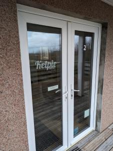 a revolving door in a building with a hello sign on it at Tangles & Kelpie in Burray Village
