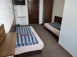 a hotel room with two beds and a tv at Motel Korona in Zamość