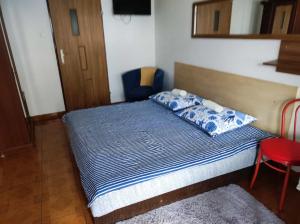 a bedroom with a bed with a blue comforter at Motel Korona in Zamość