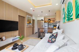 a living room with a white couch and a kitchen at Appartements avec piscine in Rawai Beach