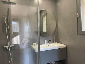 ein Bad mit einer Dusche, einem Waschbecken und einem Spiegel in der Unterkunft Carolienne in Vallauris