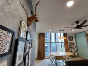 a living room with a table and a deer head on the wall at 3 Elements Premium Suite-MRT2 Station-Wifi- Self Check-iN in Kampong Batu Sembilan