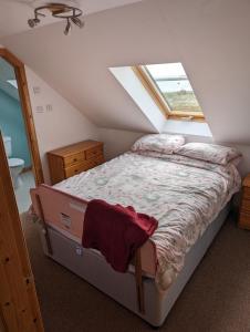 a bedroom with a bed in a attic at Tangles & Kelpie in Burray Village