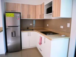 a kitchen with a stainless steel refrigerator and white cabinets at Nikla's apartment in Potrero