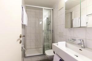 ein Bad mit einer Dusche, einem Waschbecken und einem WC in der Unterkunft Union Light - Self Check-In Hotel in Luzern