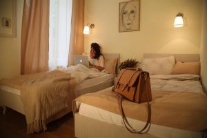 una mujer sentada en la cama usando un ordenador portátil en Bed&Breakfast kod Smilje en Belgrado