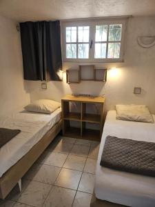 Cette chambre comprend 2 lits et une fenêtre. dans l'établissement Les Portes Du Soleil, à Bagnols-en-Forêt