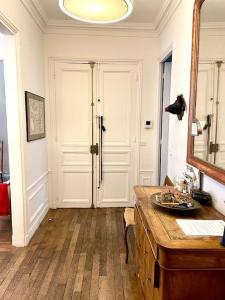 a room with a table and a mirror and a door at Grand appartement Champ de Mars in Paris