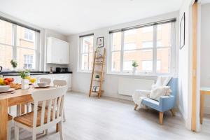 a kitchen and dining room with a table and chairs at Heart of London's Holborn - CityApartmentStay in London
