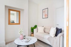 Heart of London's Holborn - CityApartmentStay في لندن: غرفة معيشة مع أريكة بيضاء وطاولة