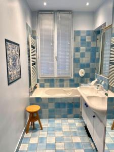 a blue and white bathroom with a tub and a sink at Grand appartement Champ de Mars in Paris