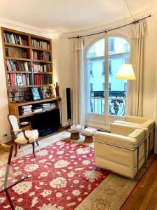a living room with a couch and a large window at Grand appartement Champ de Mars in Paris