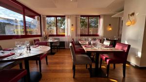 un comedor con mesas, sillas y ventanas en Logis Hôtel La Terrasse Fleurie en Divonne-les-Bains